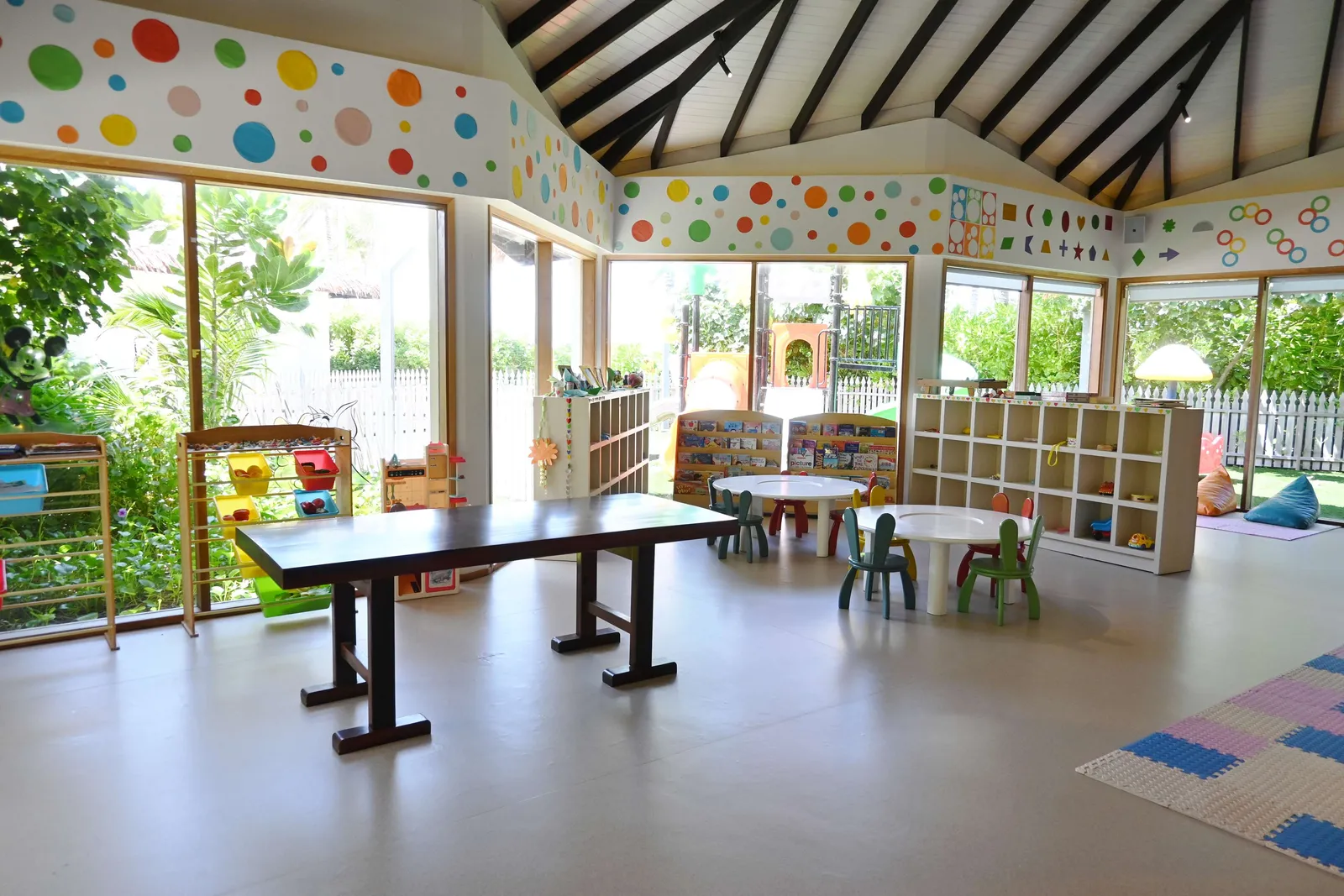 The kids’ club room, with low tables, shelves of games and polka-dot walls, open to the garden.