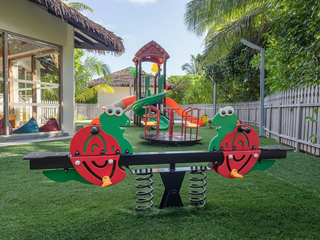 The kids’ club outdoor playground, with a turtle see-saw and a slide.