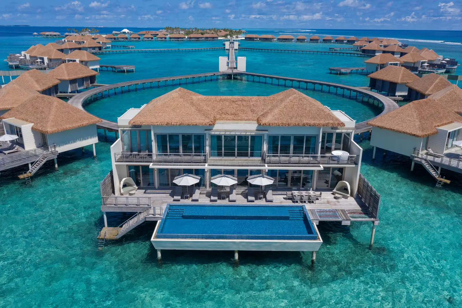 The 2-storey presidential villa at the end of its jetty, its pool on the deck and the other villas around.