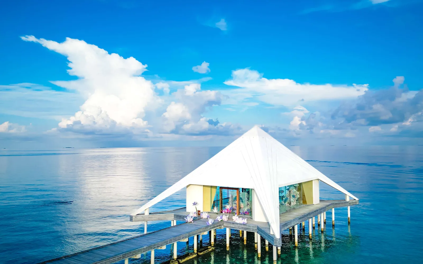 The white, pointed wedding chapel on stilts in the lagoon.