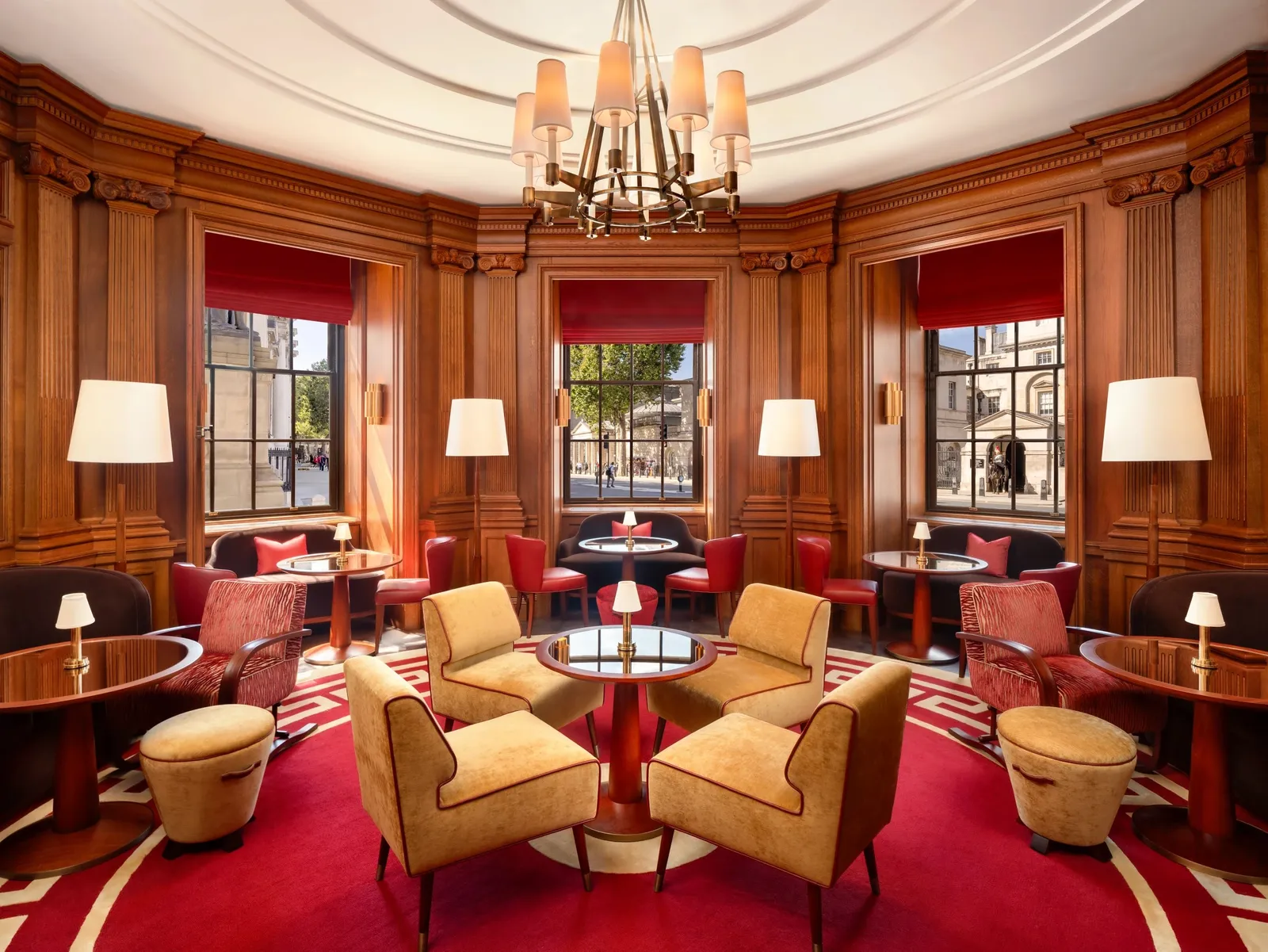 The Guards Bar: wood-panelled walls, yellow armchairs, a red carpet and chandeliers, with windows onto Whitehall