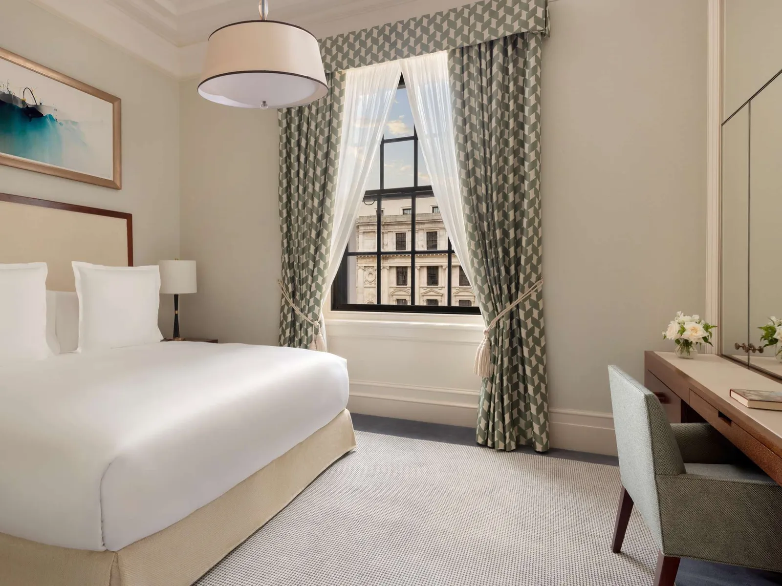 A Classic room: a white king bed, green check curtains, an armchair and a desk under a tall window