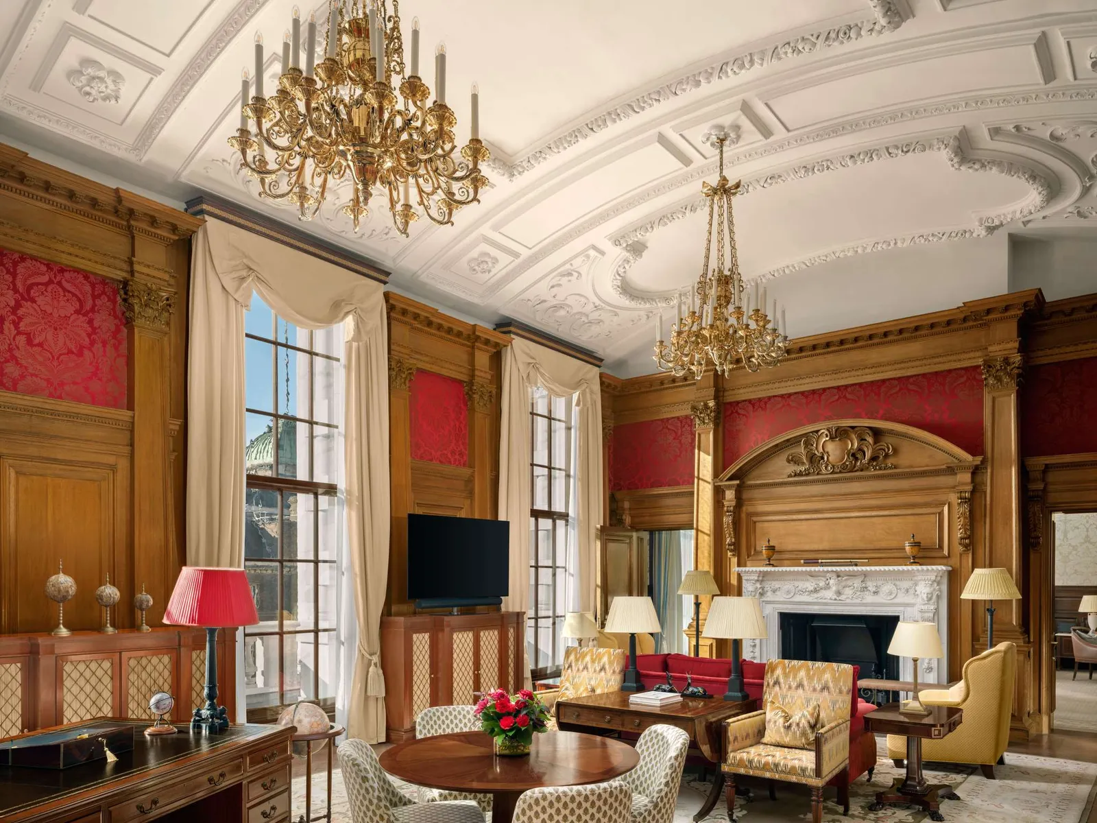 The Haldane Suite: red walls and oak panelling, gilded chandeliers, a fireplace and a plasterwork ceiling