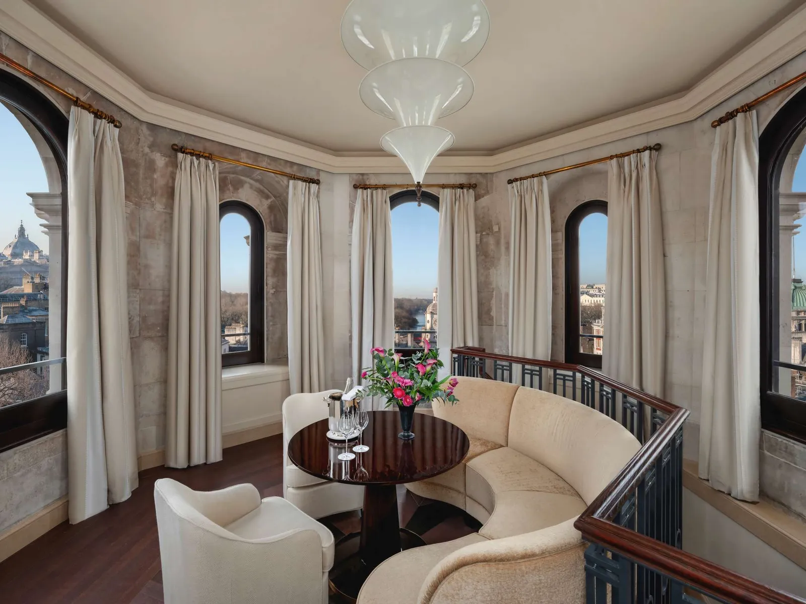 The Turret Suite’s sitting room in the turret: a curved cream sofa, arched windows and a round table