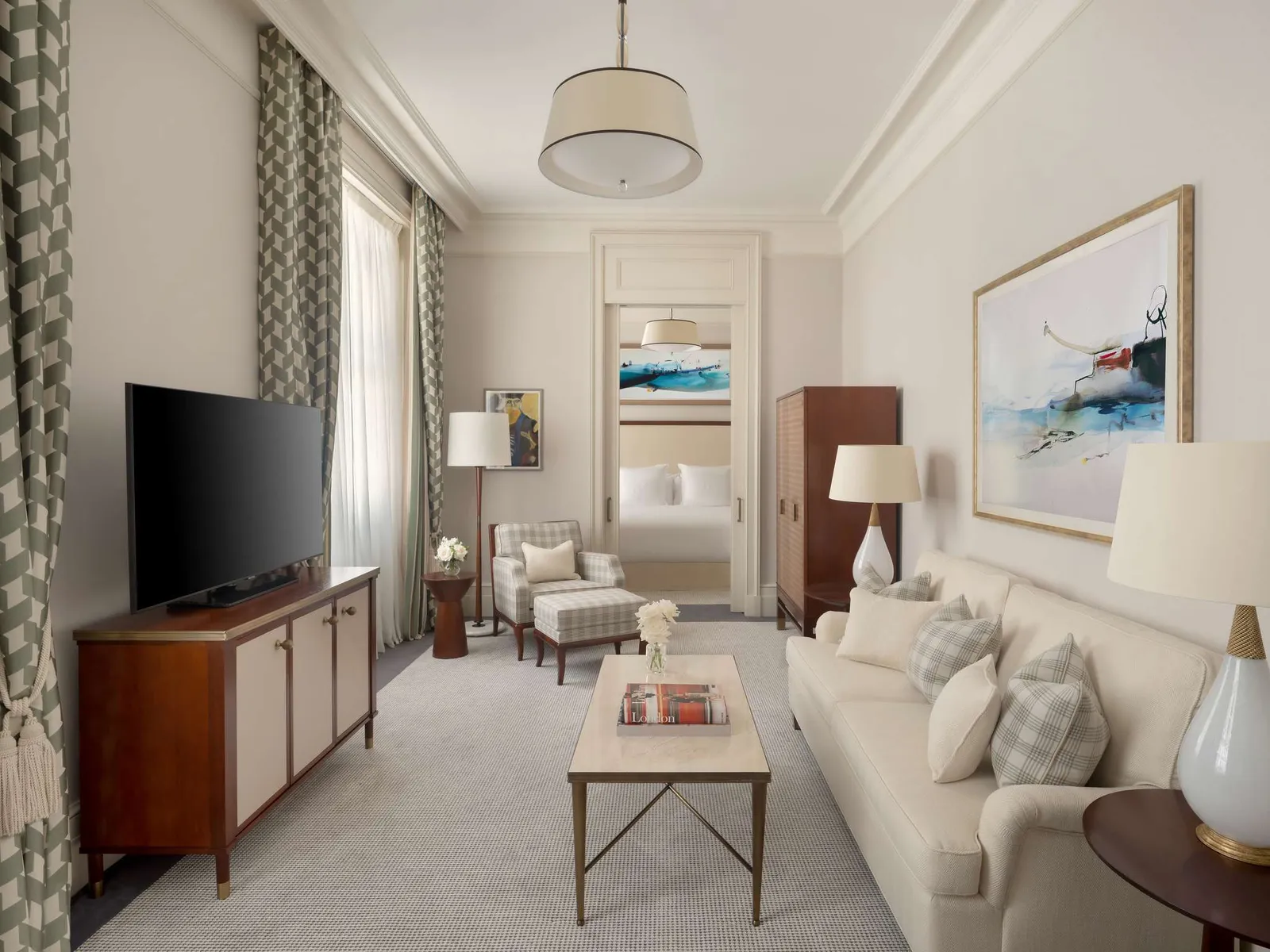 A Westminster Suite’s sitting room: a pale sofa, a television, pictures and a floor lamp