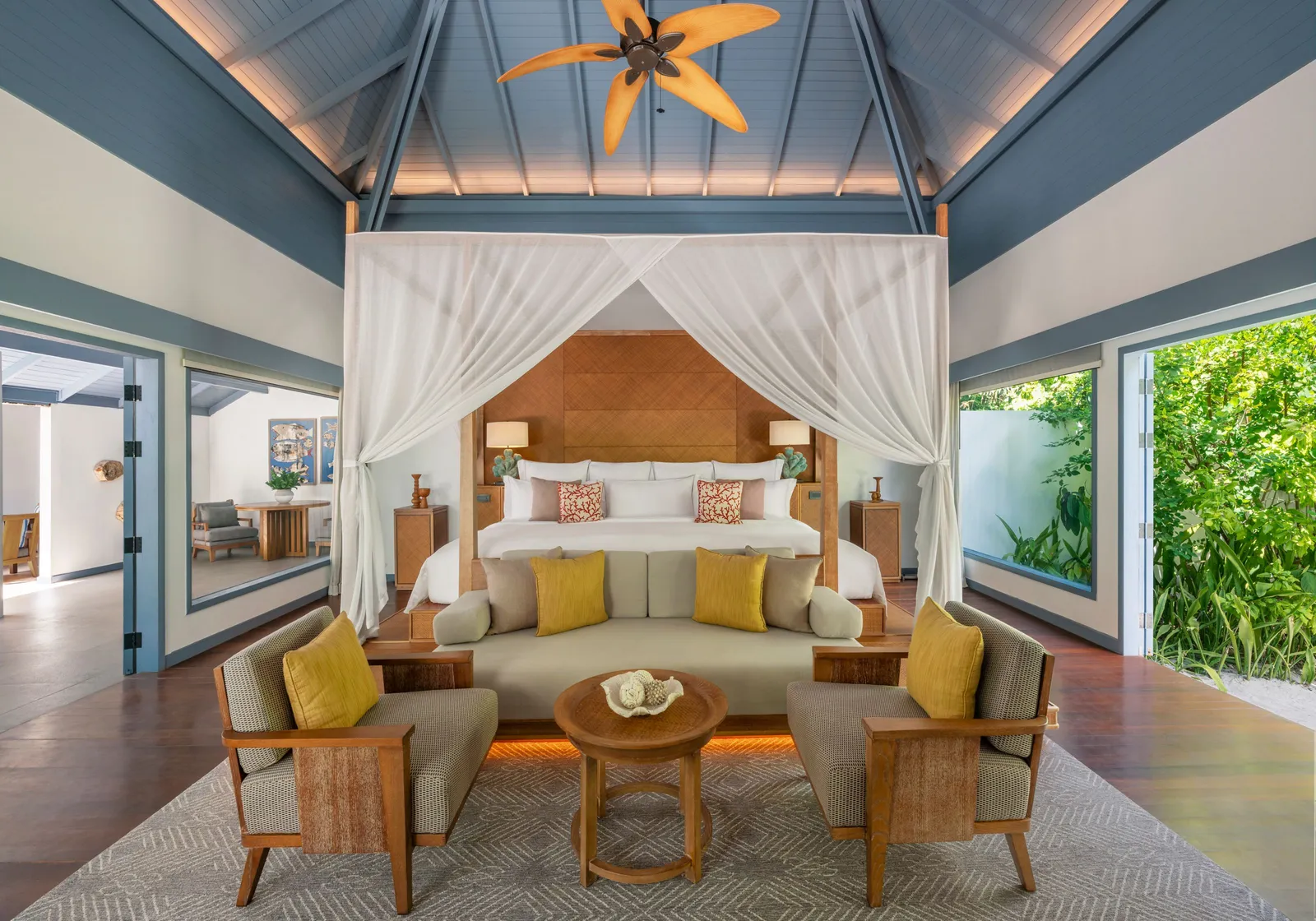 A family villa’s main bedroom, its canopy bed and windows onto the greenery