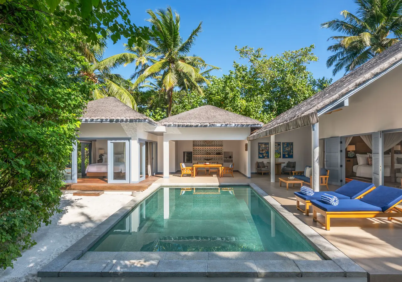 A 2-bedroom family villa’s pool, blue loungers and the villa beyond