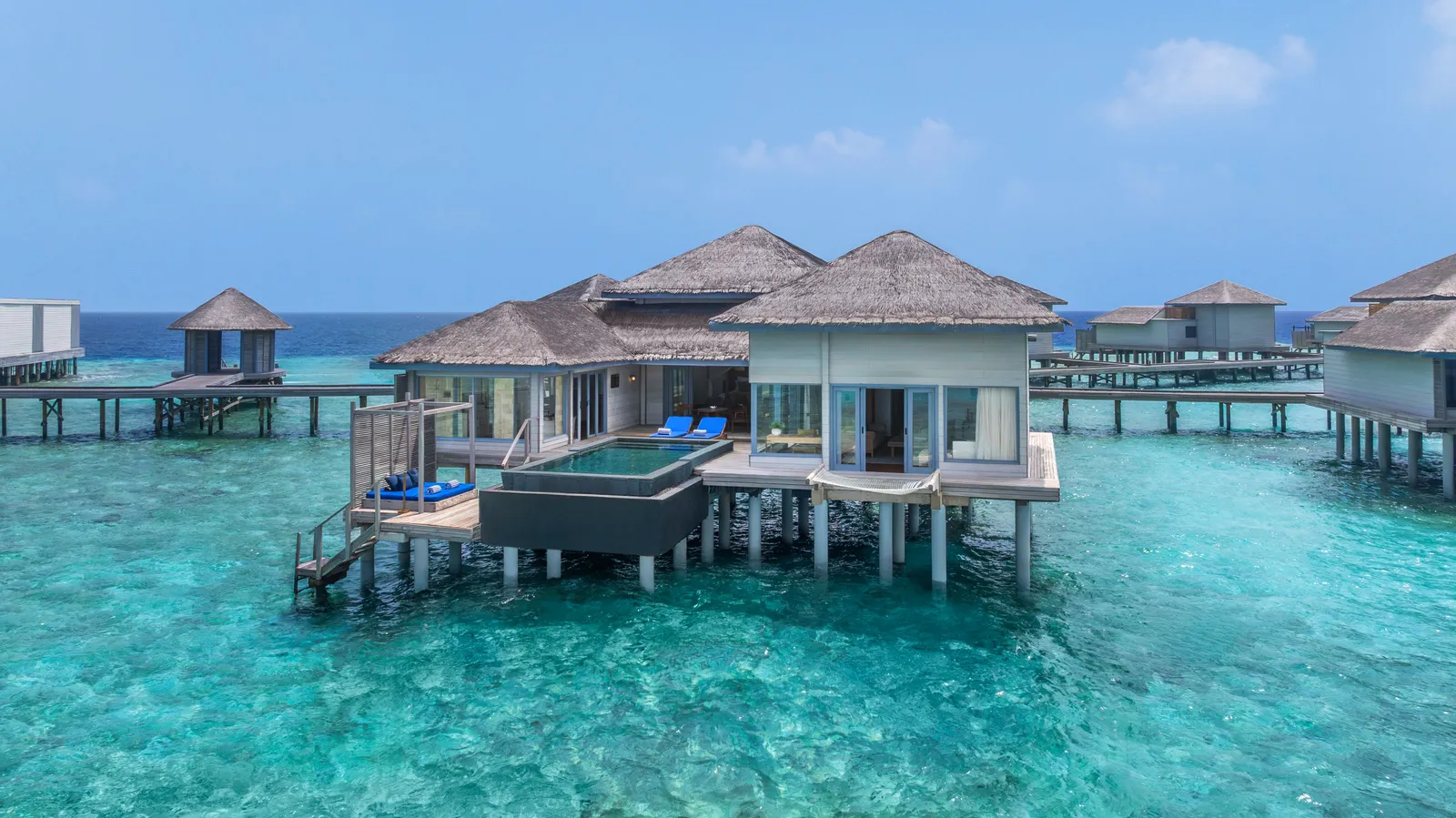 The sunset-side overwater pool villas above the turquoise lagoon