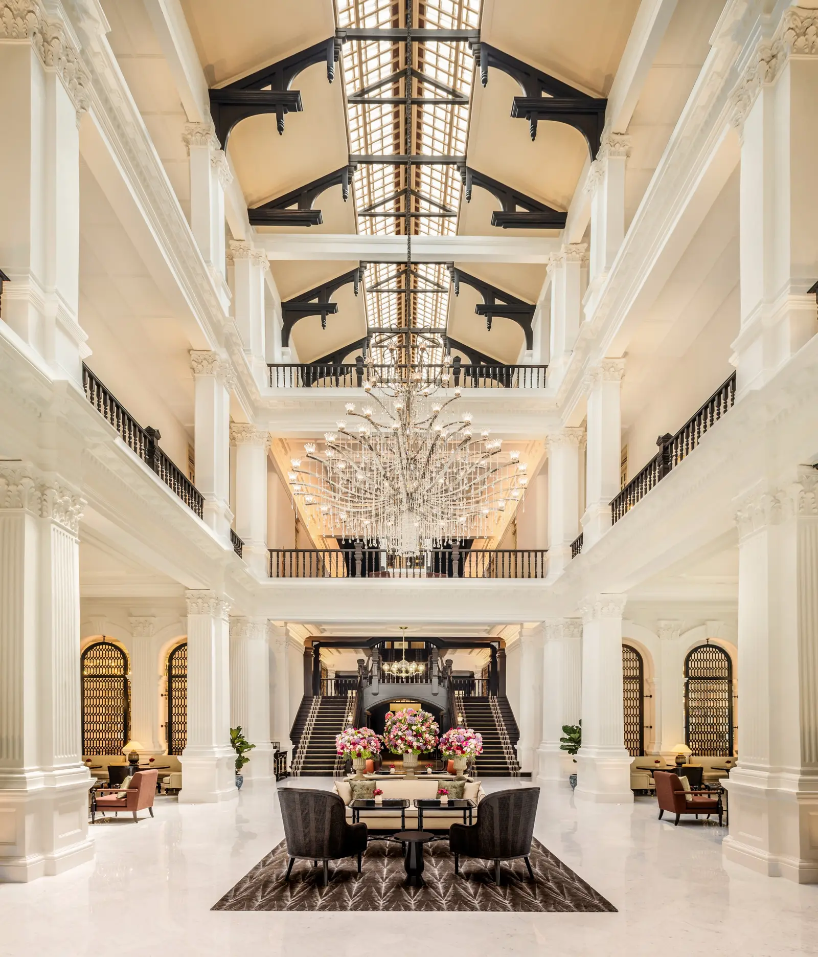 The Grand Lobby seen from the entrance: 2 floors of white galleries above the hall, the skylight, the crystal chandelier and the tea tables.
