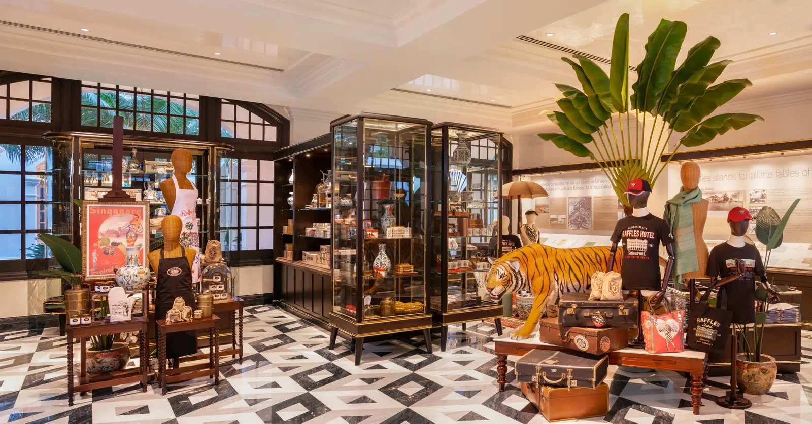 Raffles Boutique: dark-wood cabinets, mannequins, travelling trunks and a model tiger on the lozenge-tiled floor.