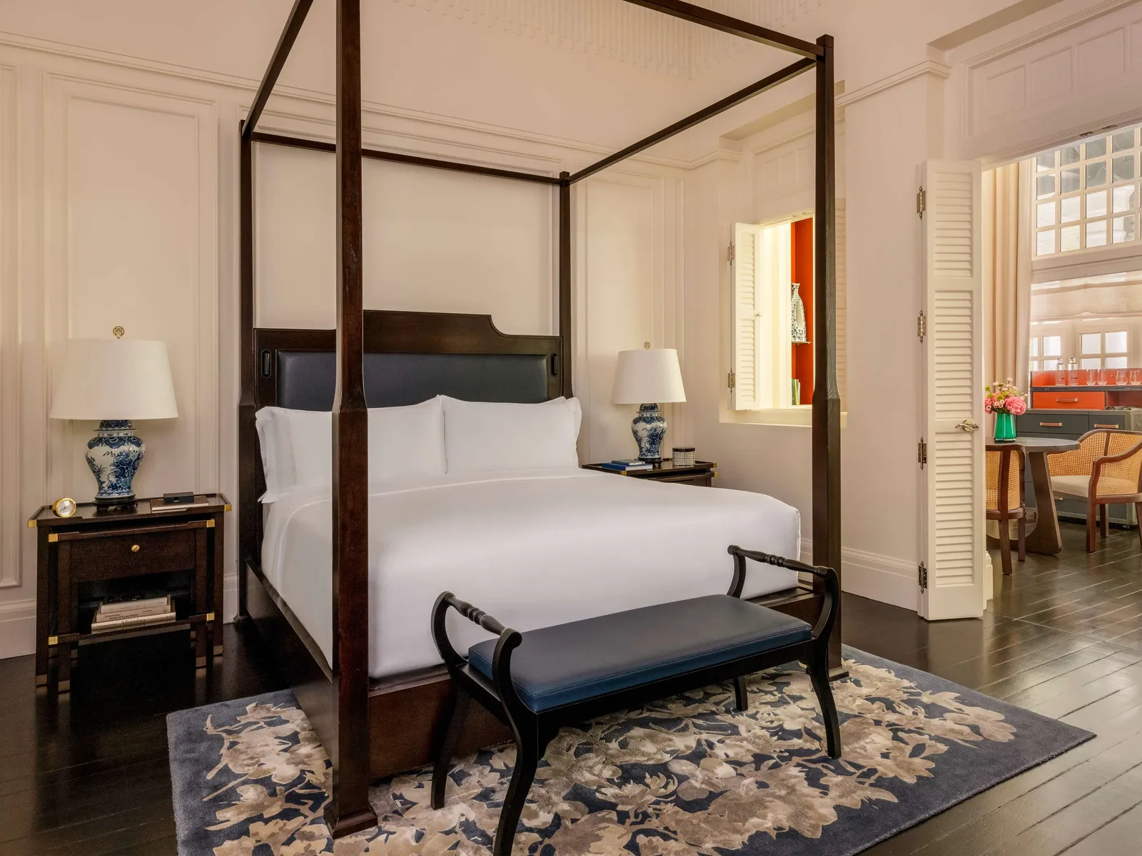 A Palm Court Suite bedroom: the four-poster bed between 2 blue-and-white porcelain lamps.