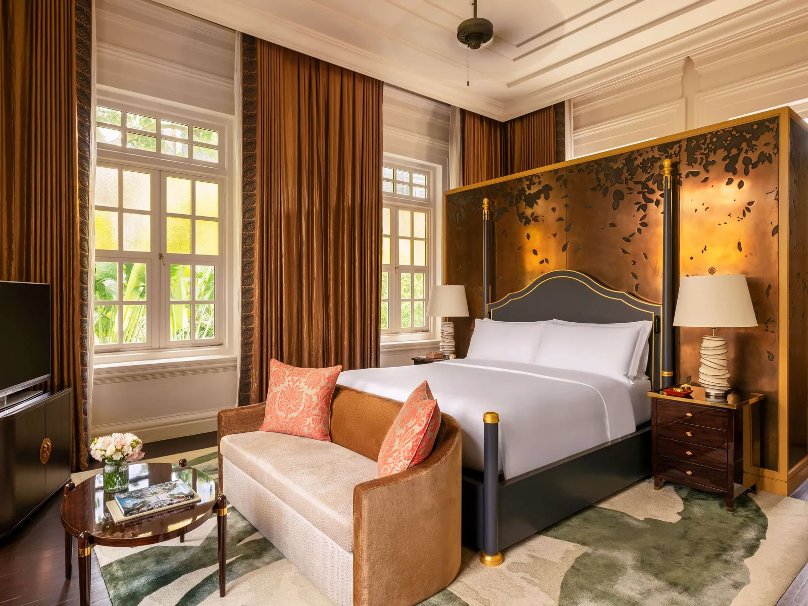 A Presidential Suite’s second bedroom: the bed in front of a gilded screen, with a sofa at its foot.