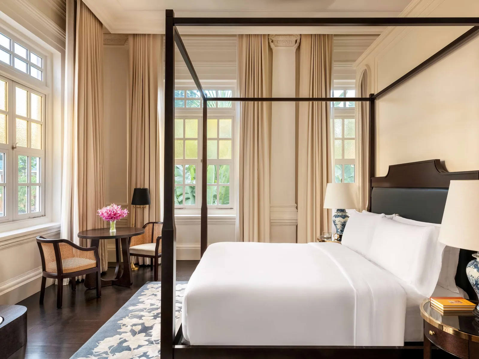 The Promenade Suite’s bedroom: the four-poster bed and a small round table by the corner windows.