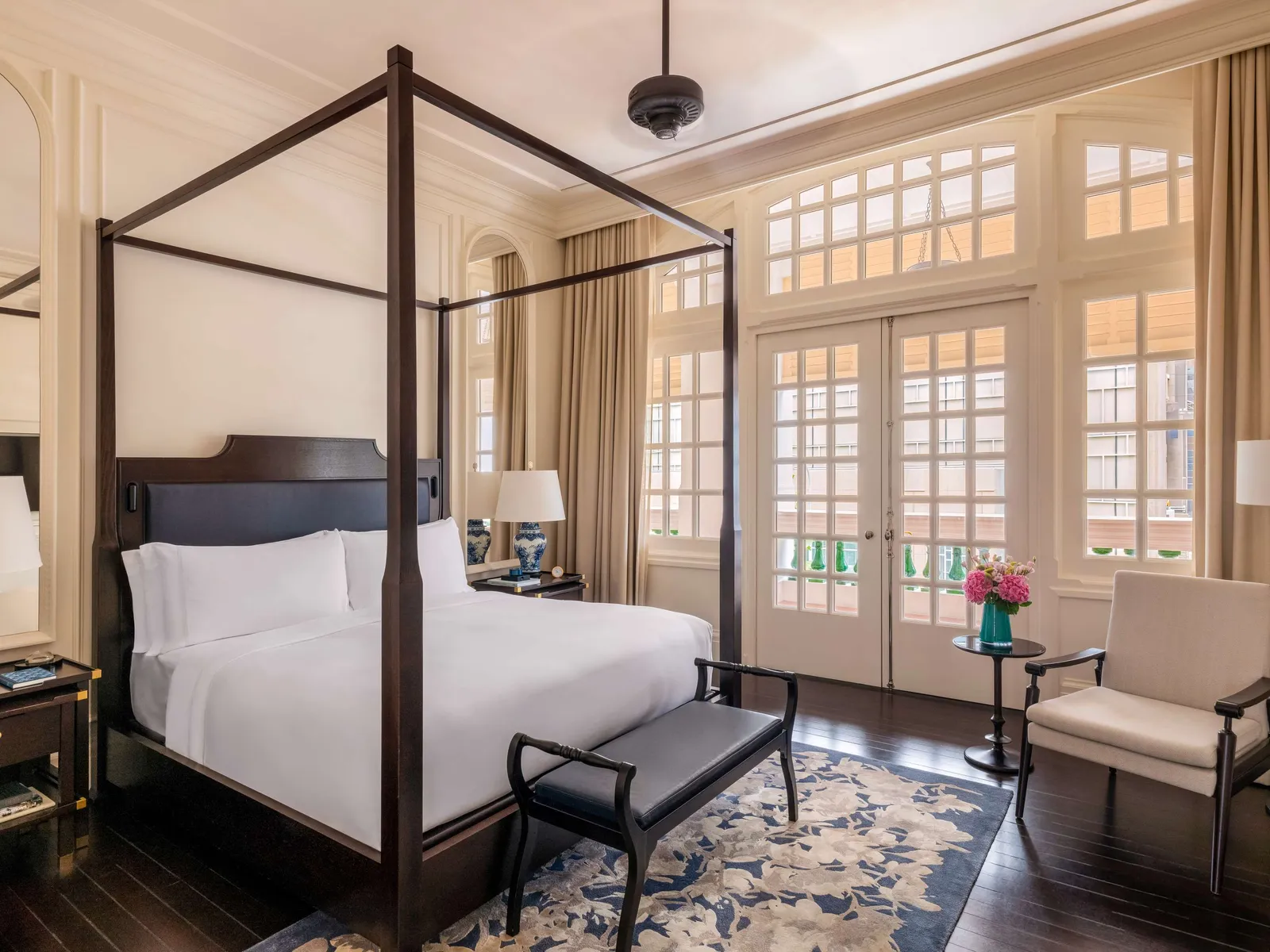 A Residence Suite bedroom: the four-poster bed and the French windows with pale curtains.