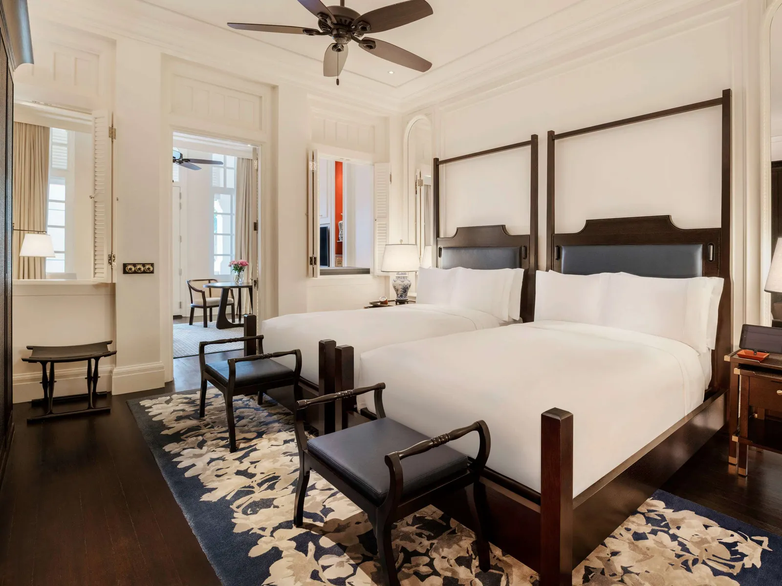 A State Room Suite bedroom with 2 double beds, their tall headboards and the ceiling fan.