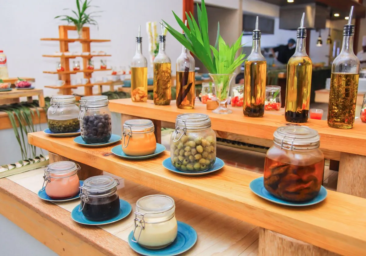 Kaagé’s pickle counter: jars of pickles, bottles of flavoured oil and plants on the timber.
