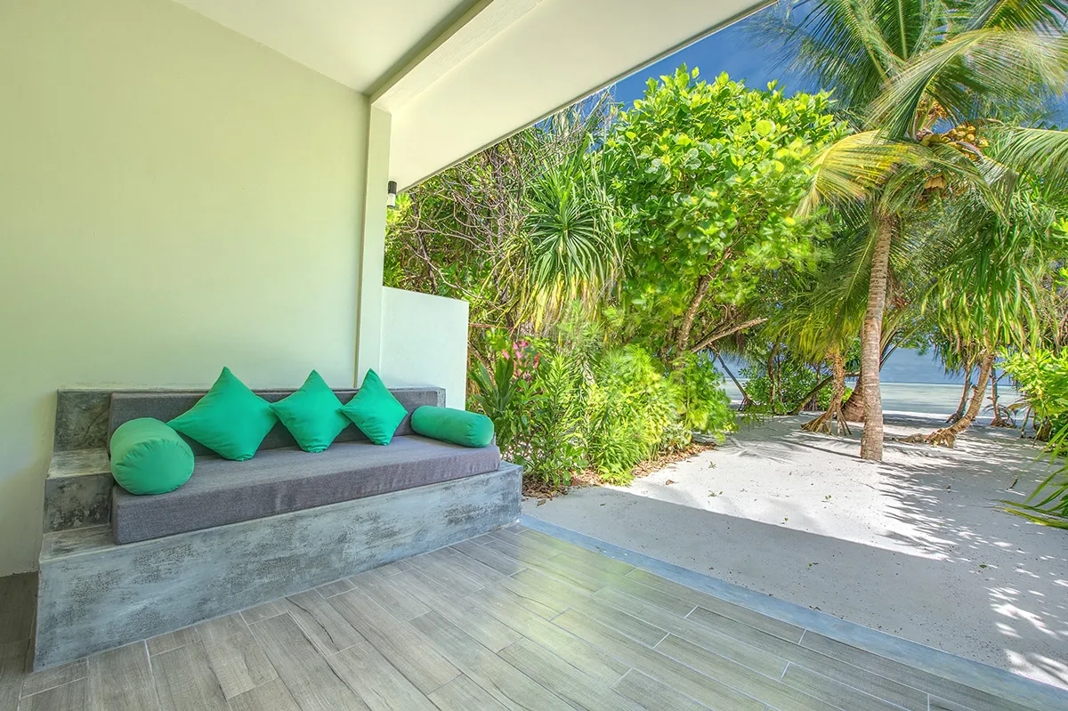 An Ocean View Villa’s terrace, with the daybed and the sandy path through the bushes to the sea.