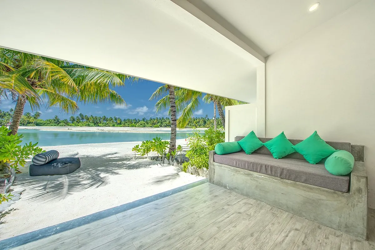 A Lake View Villa’s terrace, with the concrete daybed and green cushions facing the saltwater lake.