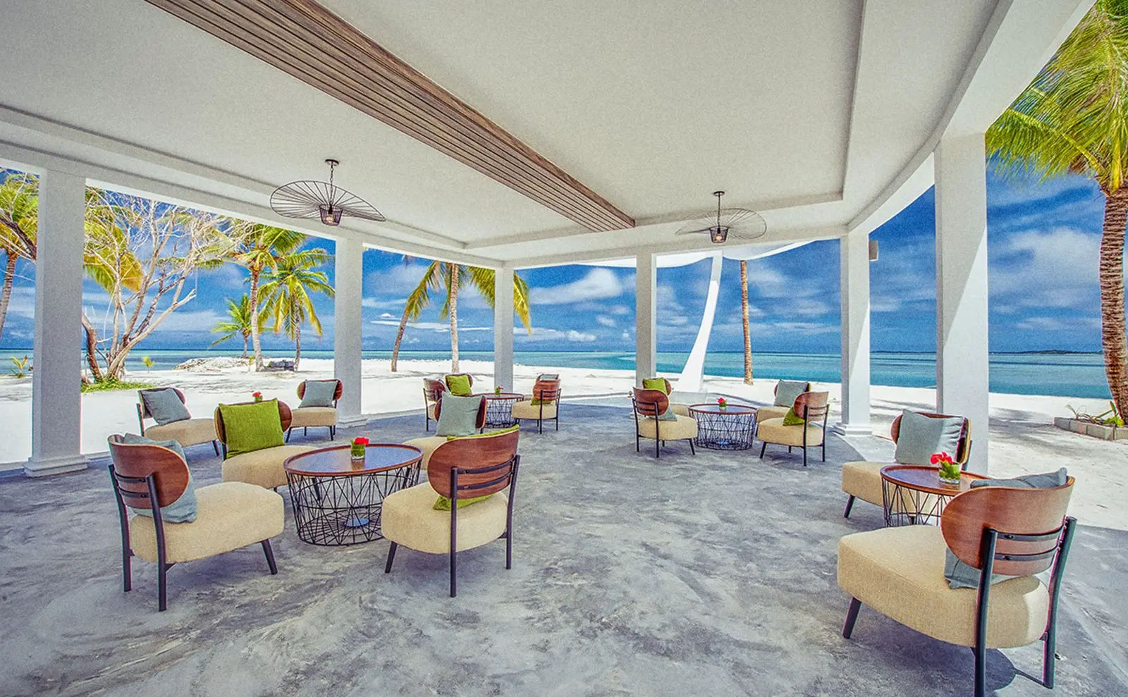 Dhirun’Bar’s covered lounge, its armchairs and low tables open to the beach and the palms.