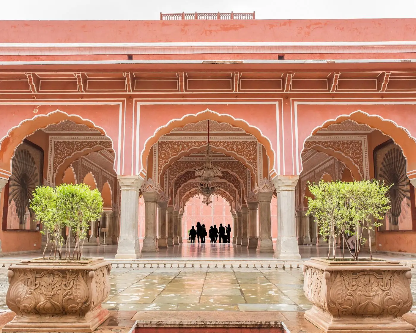 A City Palace courtyard with pink arches and potted plants