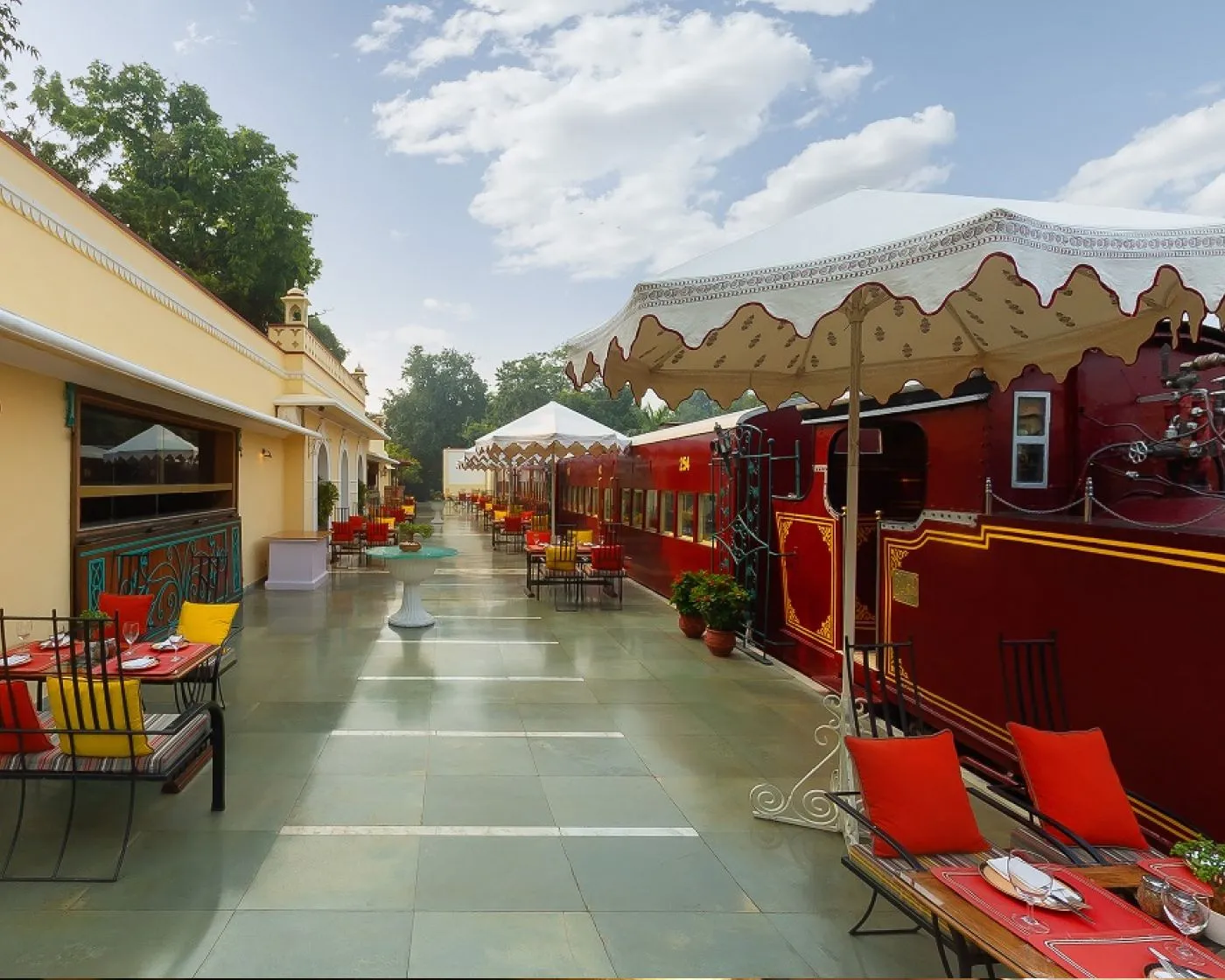 Steam, a restored red railway carriage along the platform of a recreated station