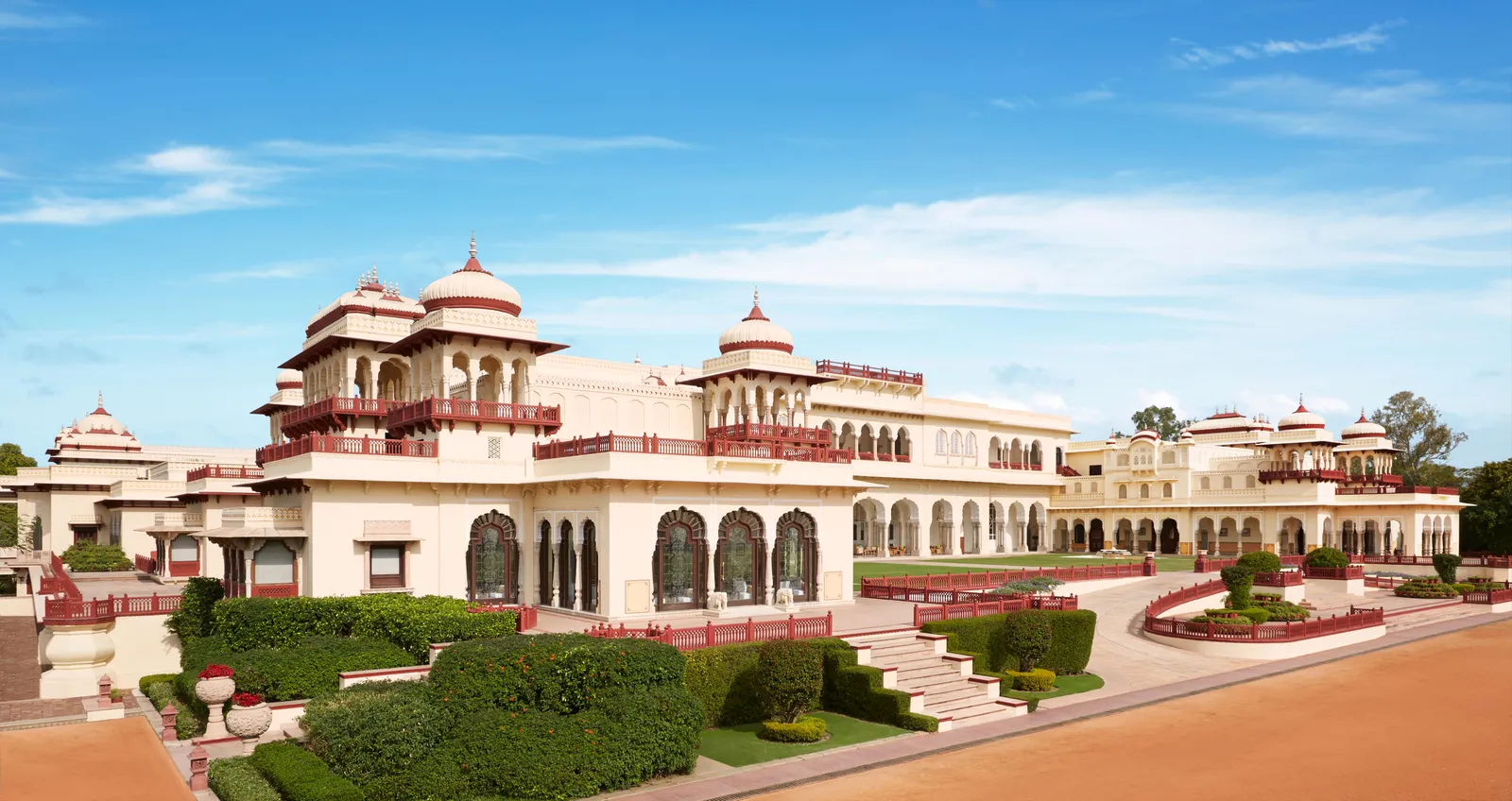 Rambagh Palace’s white façade, with domes and chhatris, above the lawns