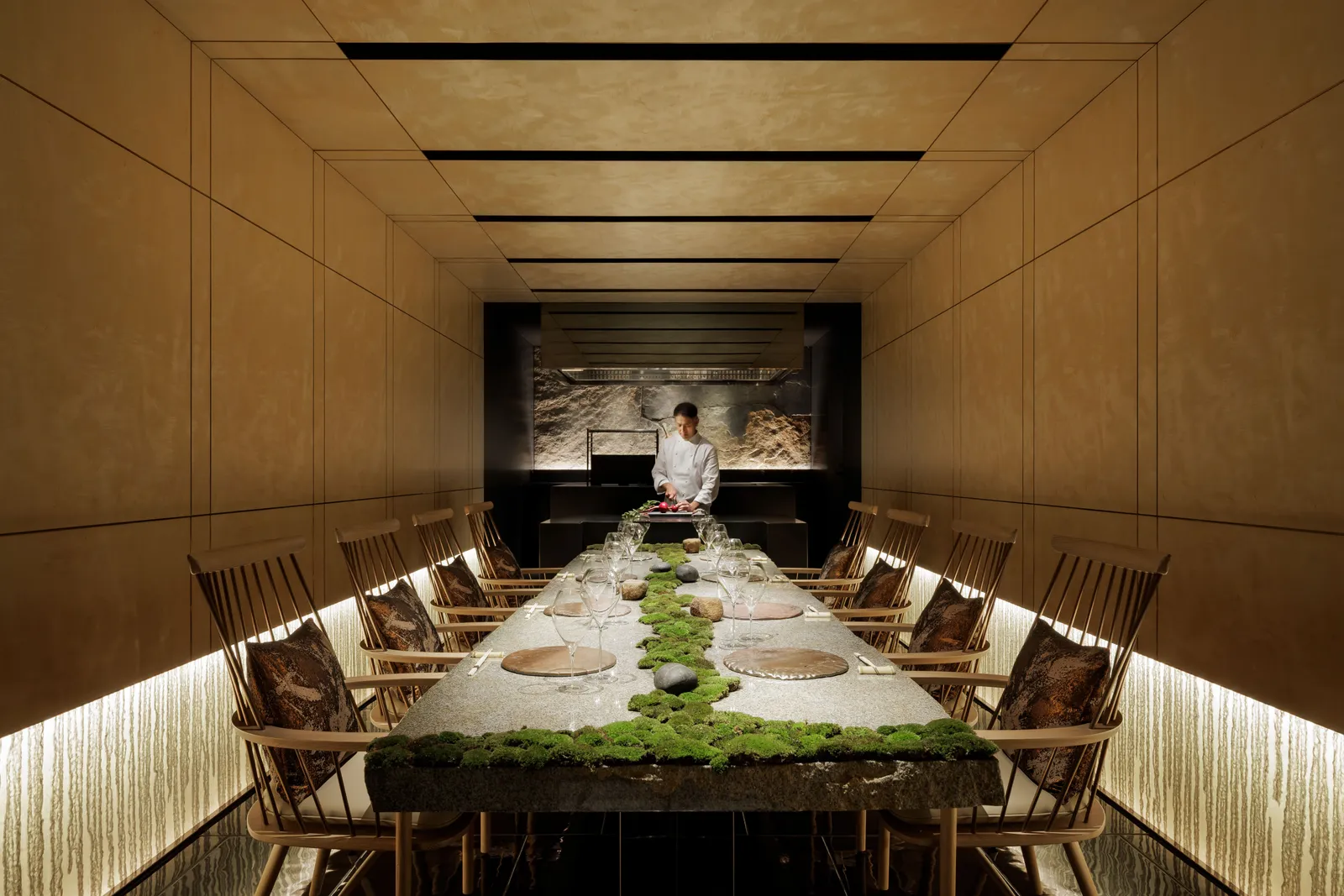 The chef’s table: one long table for 8 with a runner of moss down the middle and the chef at work at the far end.
