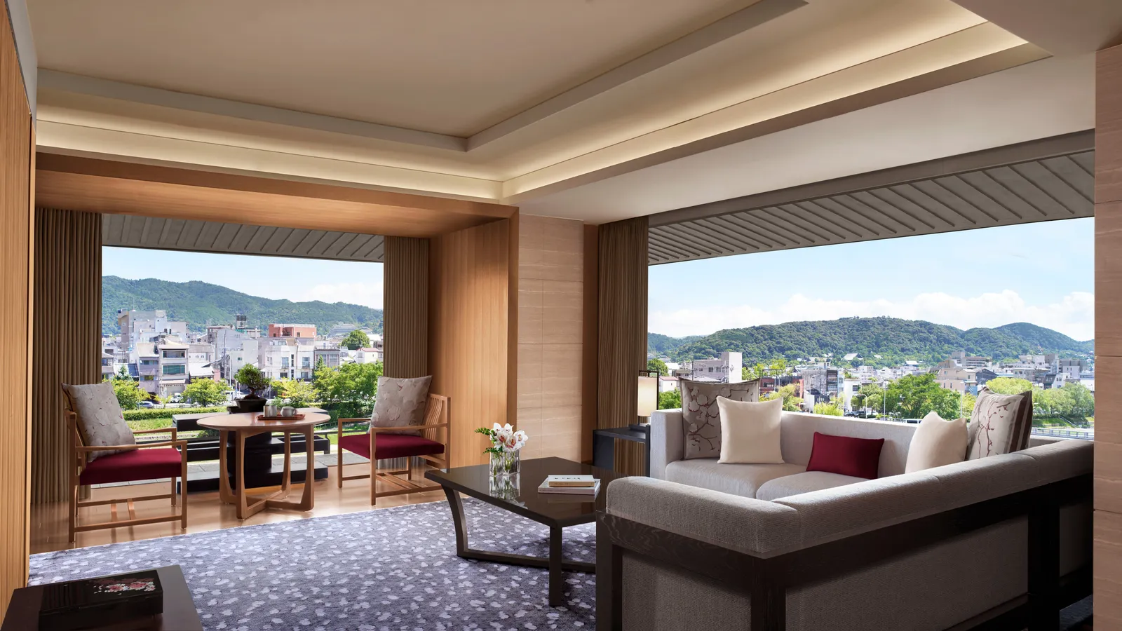 The Corner Suite MINAMI living room, its windows on 2 sides looking over the river, the city and the mountains.
