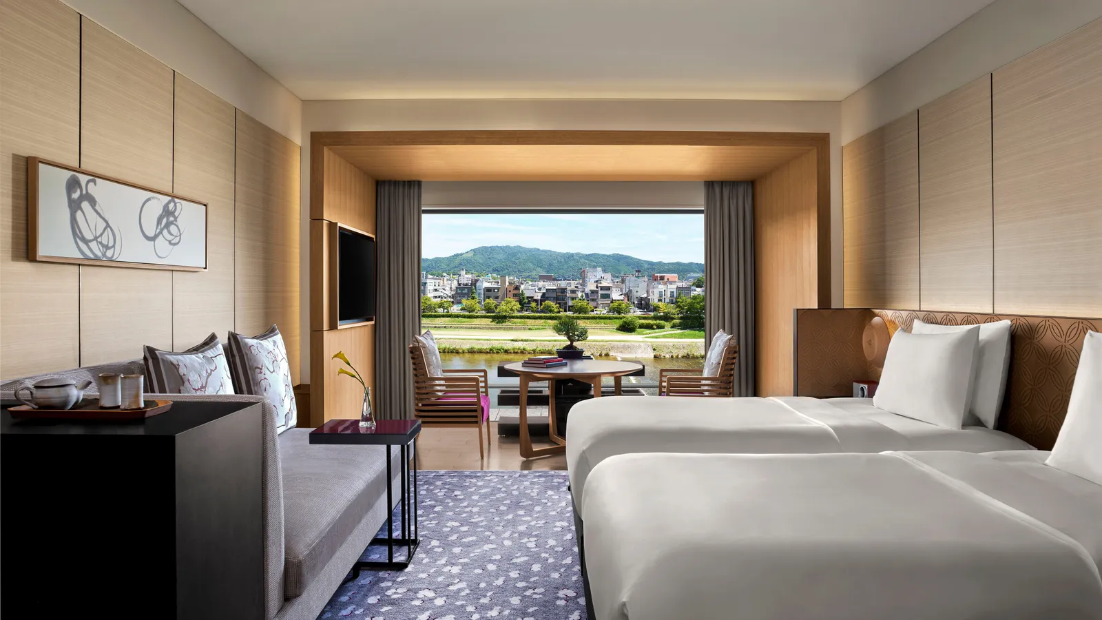 A twin Grand Deluxe Kamogawa room with the window over the Kamo: the green bank, the river and the hills beyond.