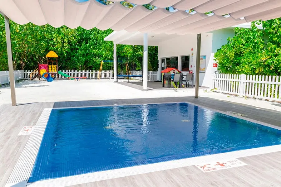 The RIU Land children’s pool under its awning, with the playground in the garden behind.