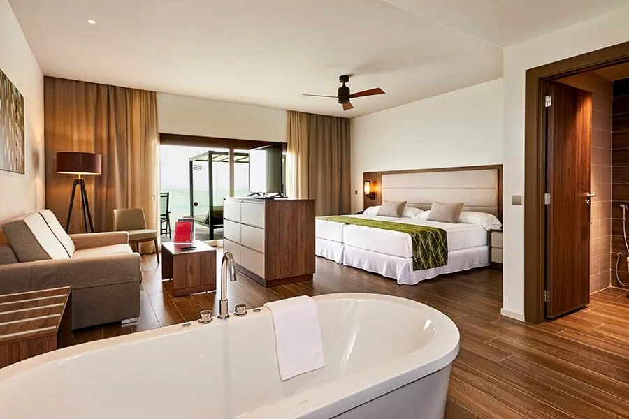 The overwater Superior Junior Suite, with its freestanding bath in front of the bed and the sitting area.