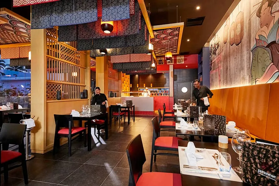 Yu Hi’s dining room, with red chairs, wooden screens, lanterns and a Japanese mural on the wall.