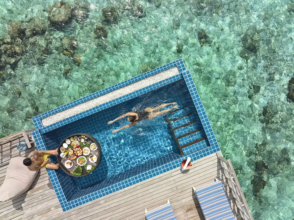 Floating breakfast from above: the round tray afloat in the private pool of a water villa.