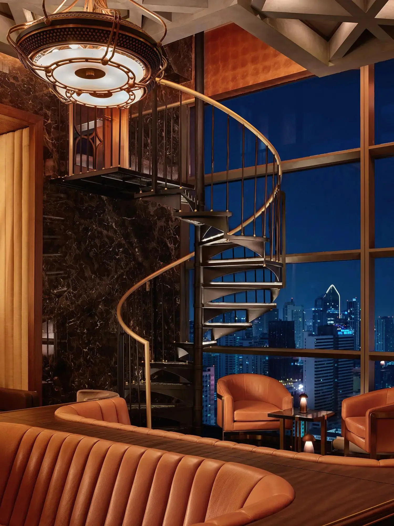 La scala a chiocciola della East Lounge di Lennon’s, con la città di notte dietro i vetri