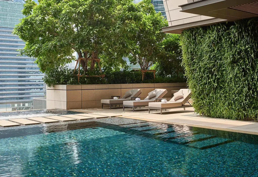 La parte all’aperto della piscina, con i lettini sotto il muro verde
