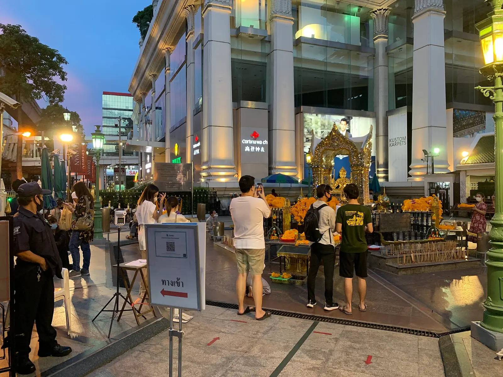 Il santuario di Erawan all’incrocio di Ratchaprasong, con i fedeli davanti all’altare