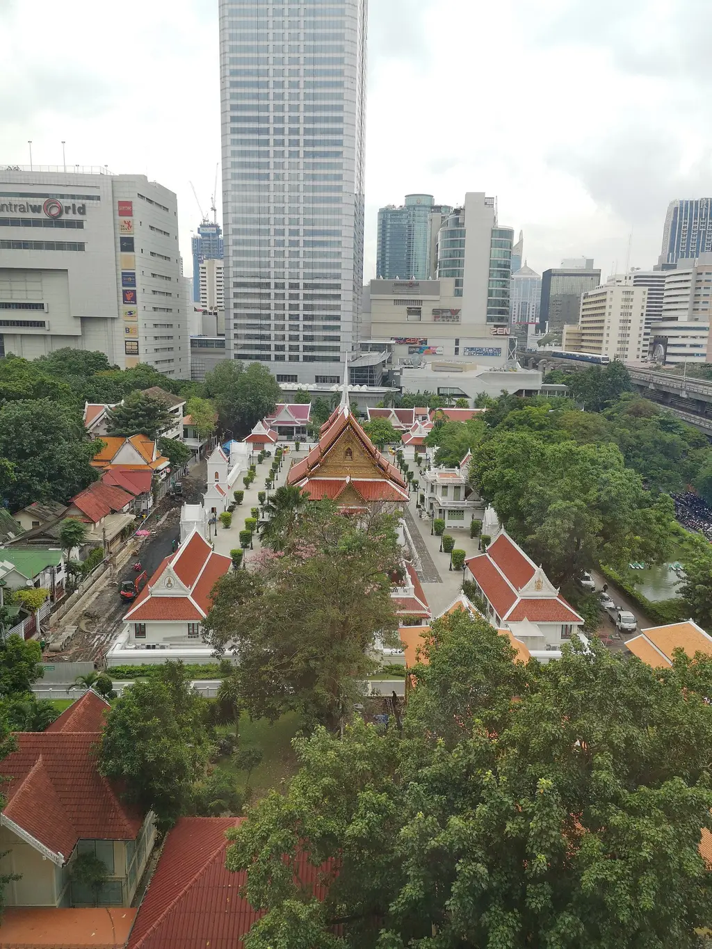 I tetti rossi e oro di Wat Pathum Wanaram fra i centri commerciali di Siam, visti dall’alto