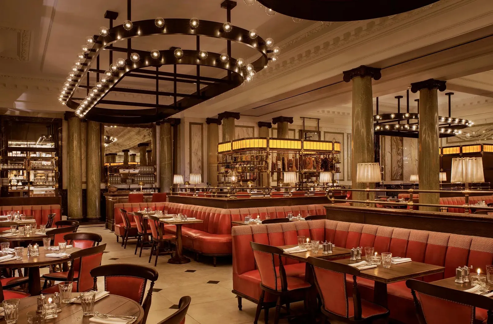 Holborn Dining Room: red leather banquettes, laid tables, columns and a chandelier of bare bulbs