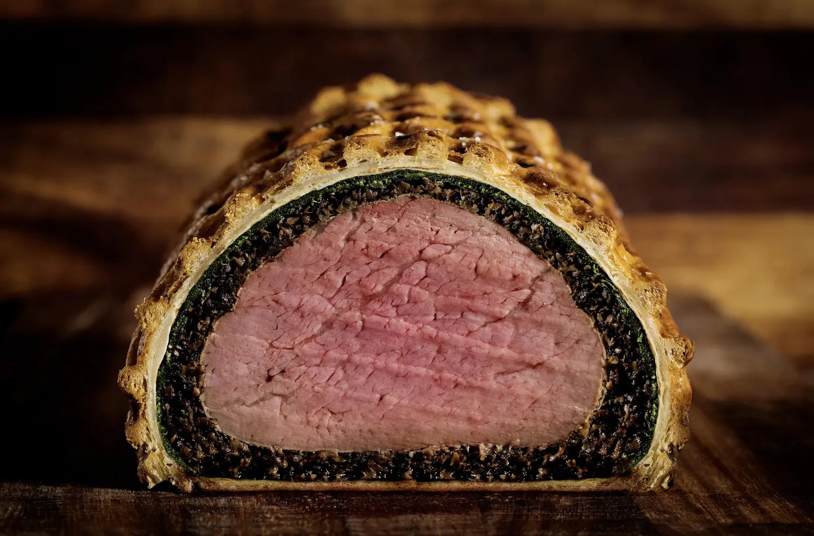 A Beef Wellington cut in half: the pink fillet wrapped in golden pastry