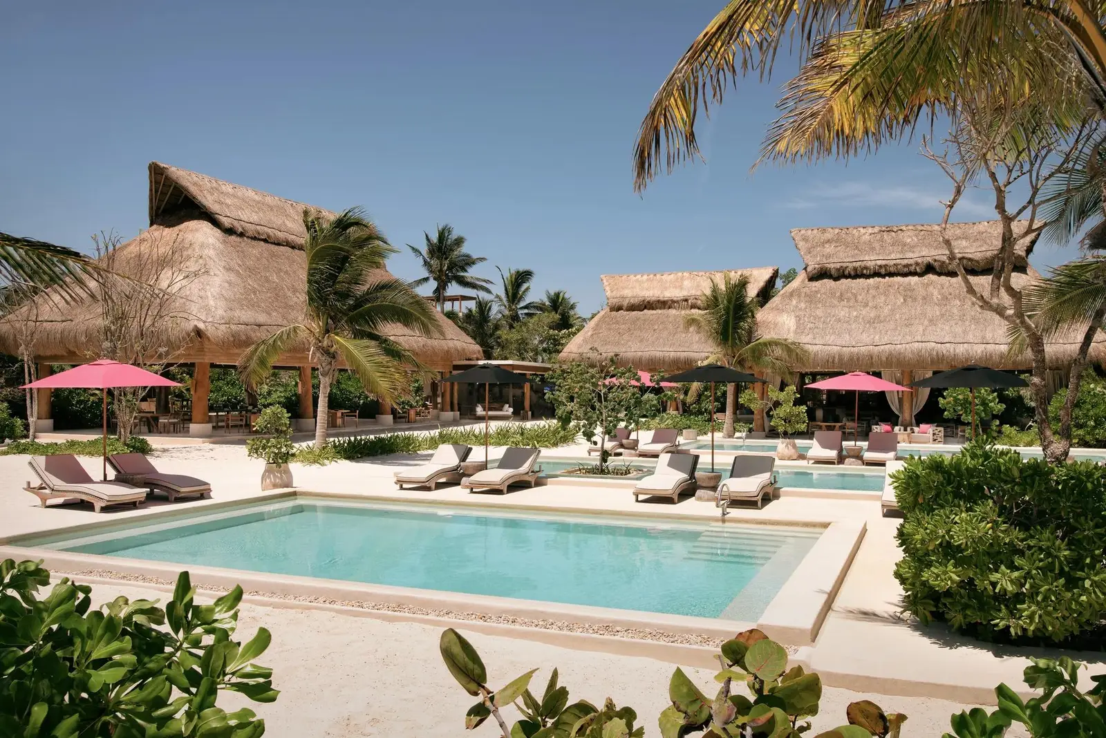 The Aquí Me Quedo pool in front of its thatched roofs