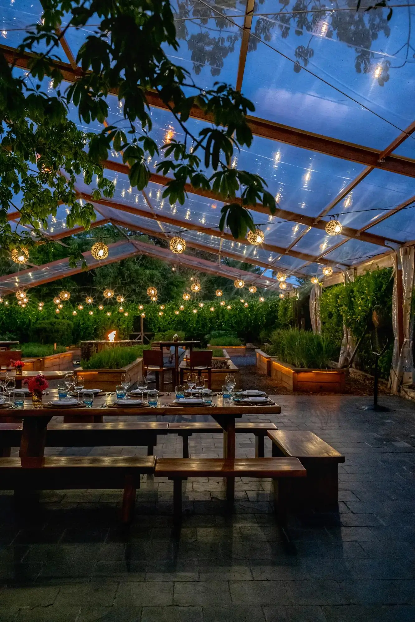 La Ceiba’s communal table under strung lights in the garden