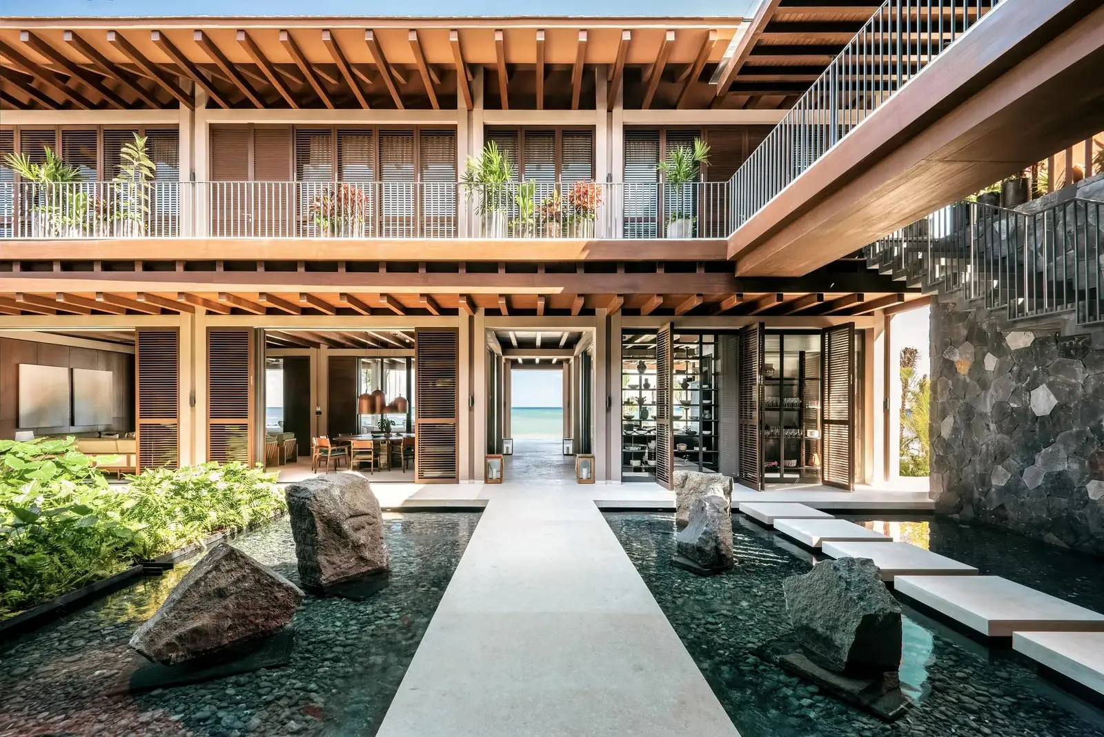 The courtyard with its pool of water and rocks between the villa’s wings