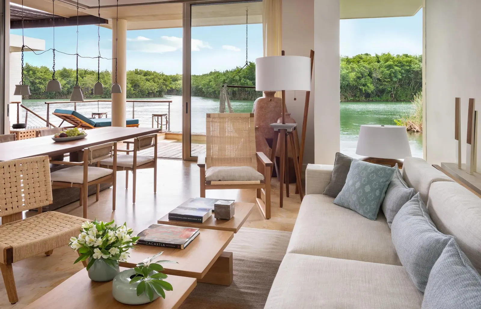 The living room over the water, the terrace and lagoon beyond the glass
