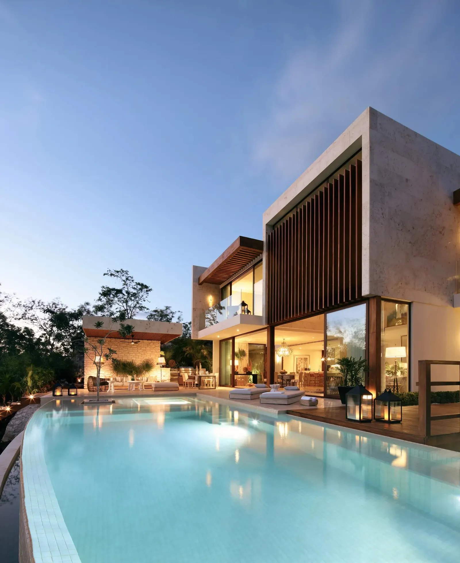 The villa at dusk, its long pool lit