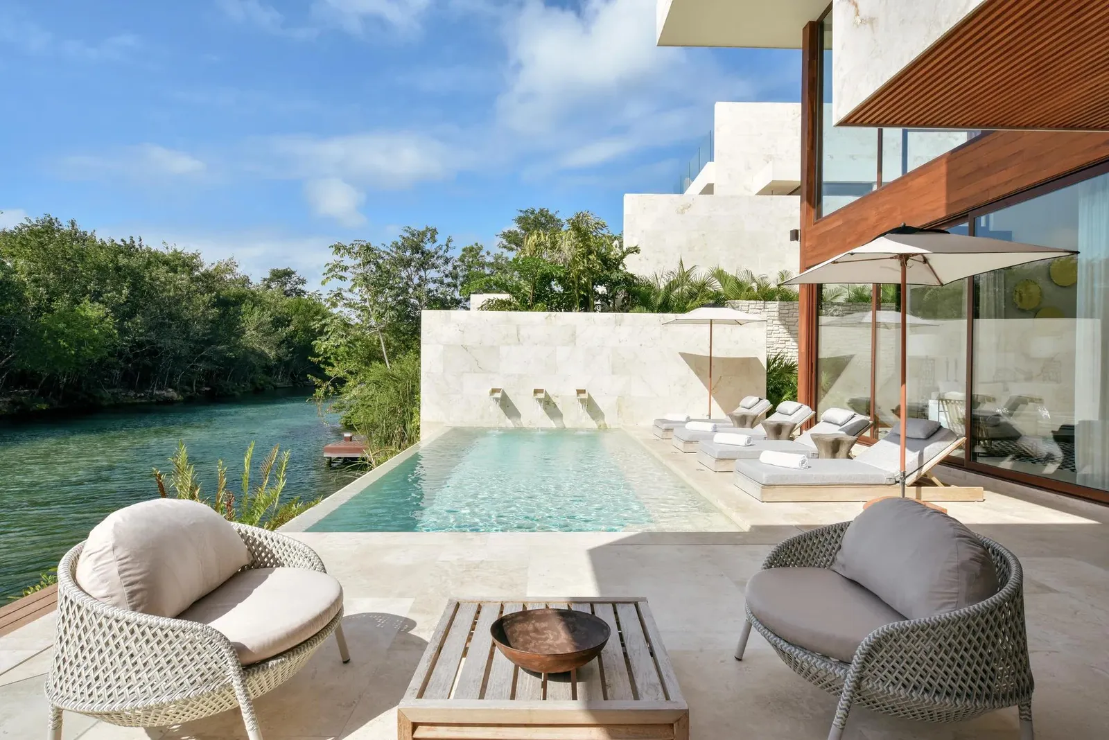 The villa’s pool and deck, armchairs facing the lagoon