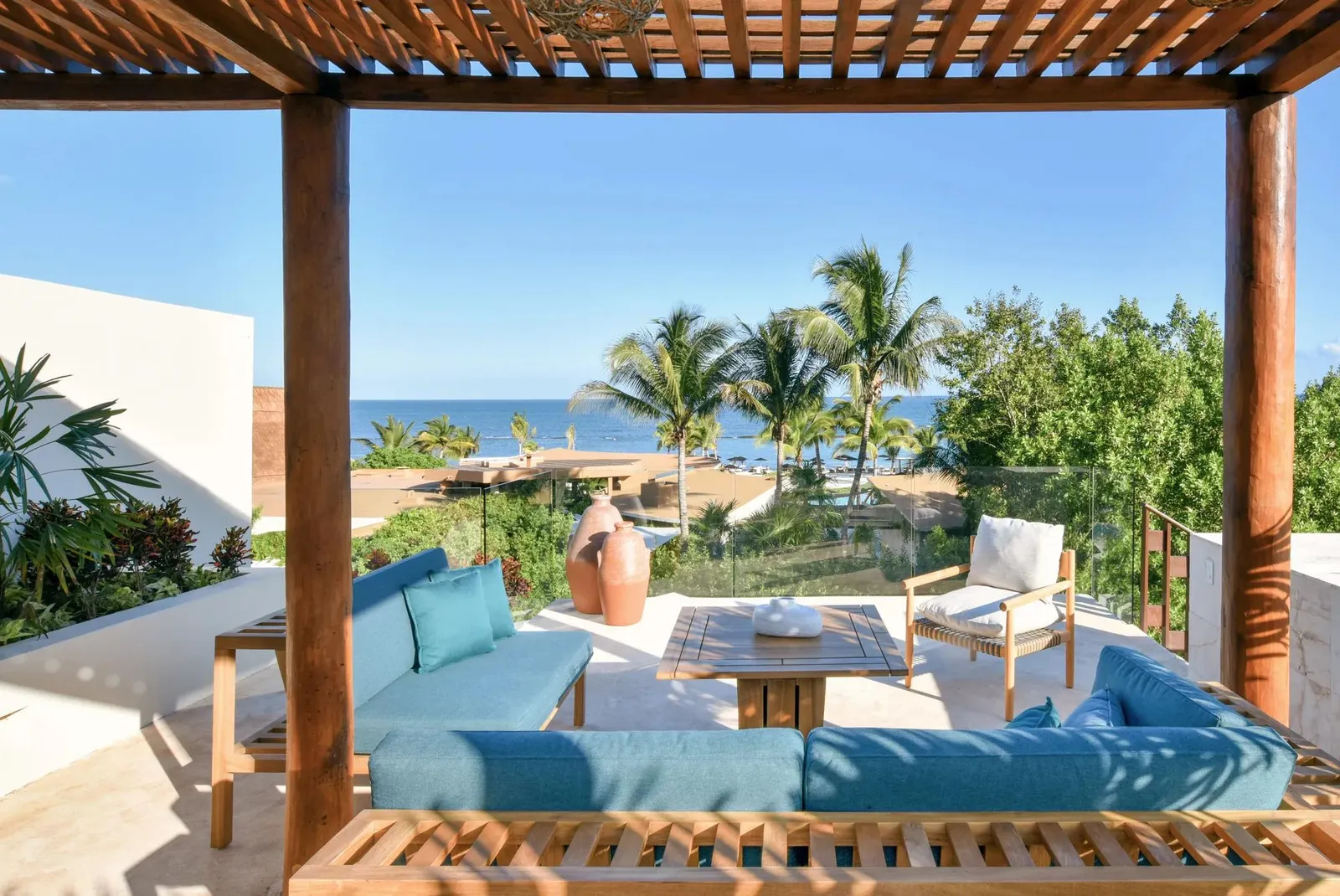 The roof terrace with sofas, palms and the sea