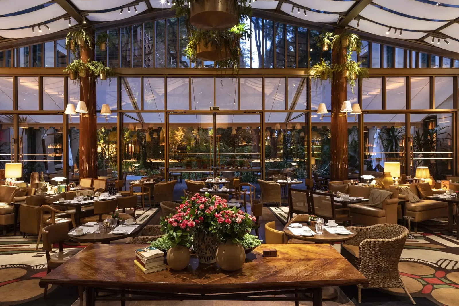 Le Jardin’s glazed dining room, with plants and laid tables