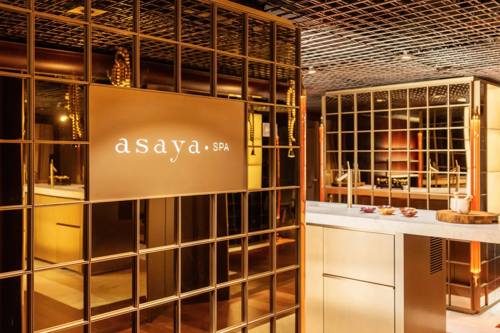 Asaya reception framed by golden metal and timber