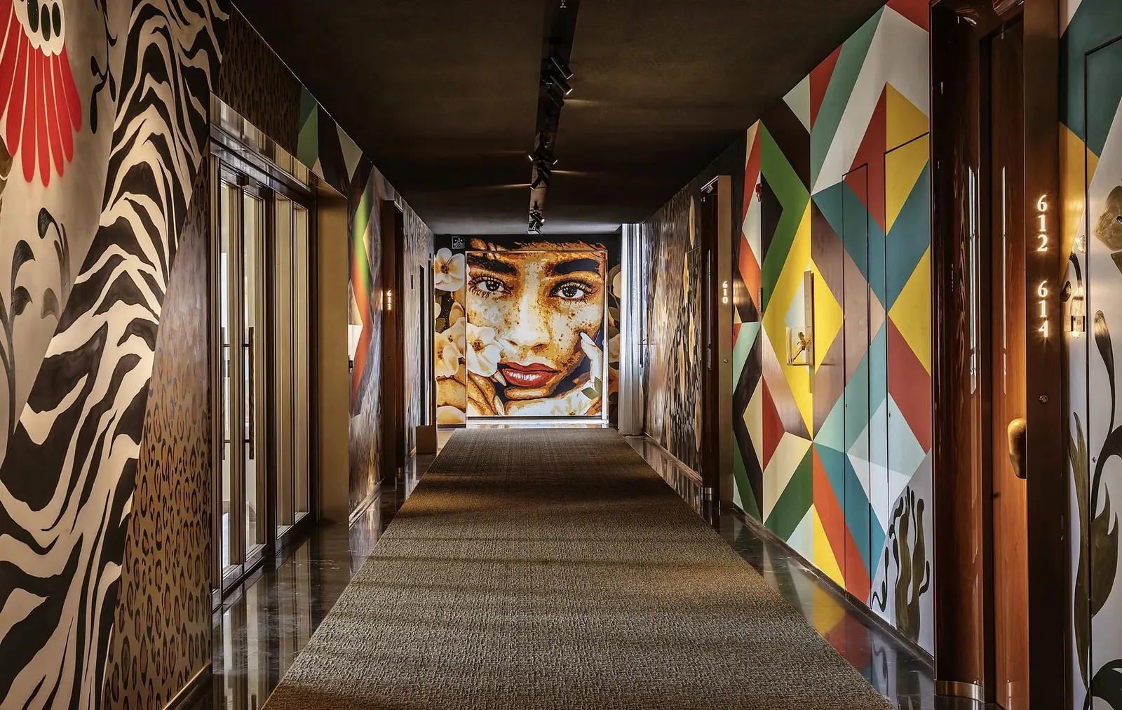 Art and geometric patterns lining a hotel corridor