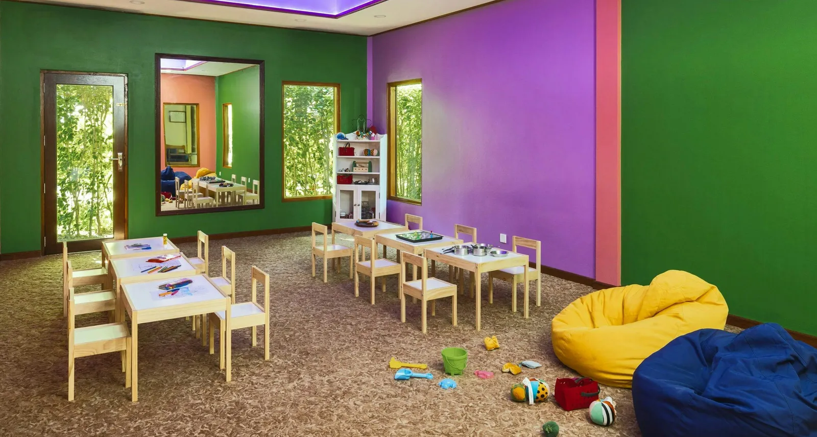 The Starfish Kids Club room, with green and purple walls, low tables, small chairs and bright beanbags.